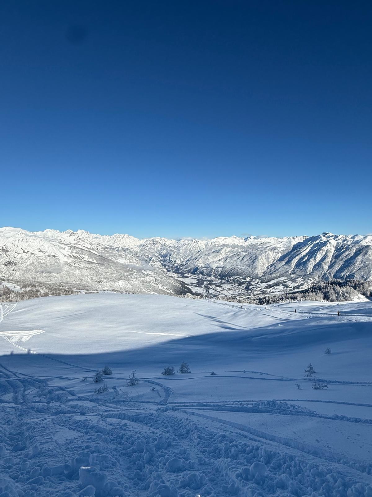 Panorama de montagnes enneigées sous un ciel bleu dégagé