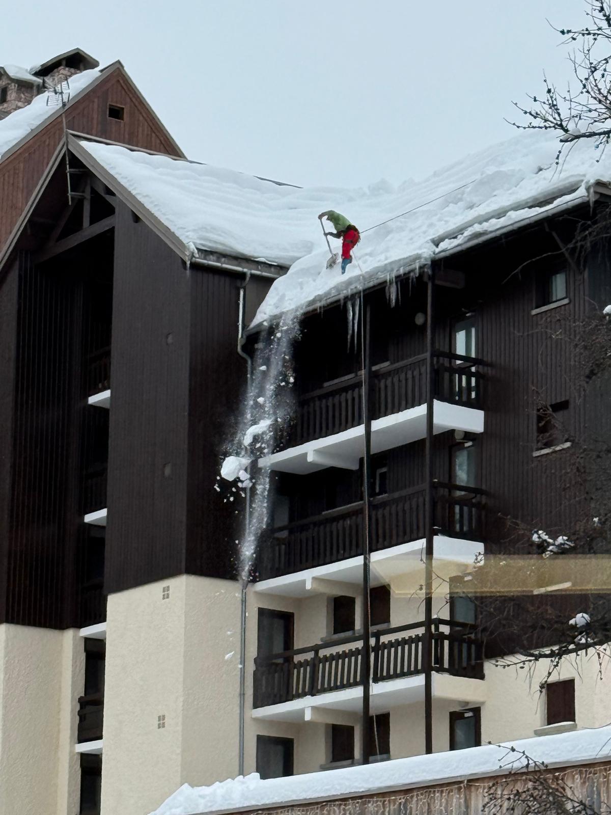 Déneigement manuel d'une toiture à Risoul suite aux fortes chutes de neige