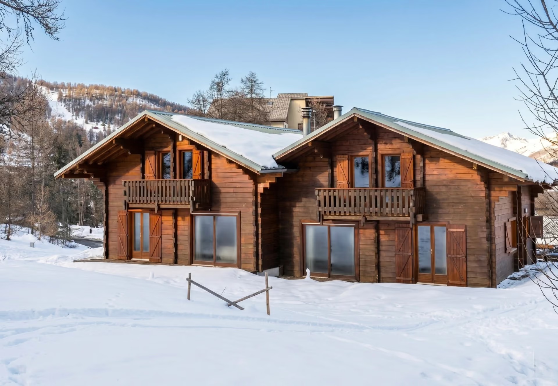 Chalet traditionnel en bois avec balcons sous un ciel bleu clair